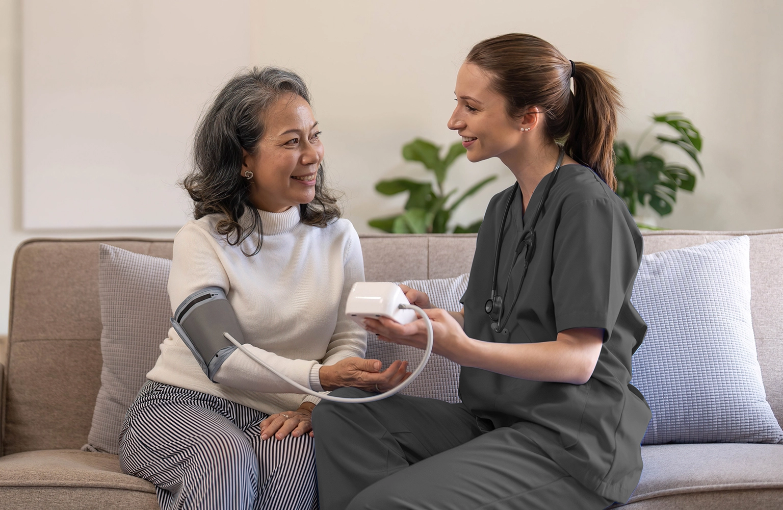 Nurse providing at-home chronic care support, helping a senior patient manage their health.