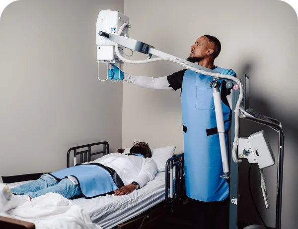 Life Medical technician using mobile X-ray equipment to perform diagnostic imaging at the patient's home.