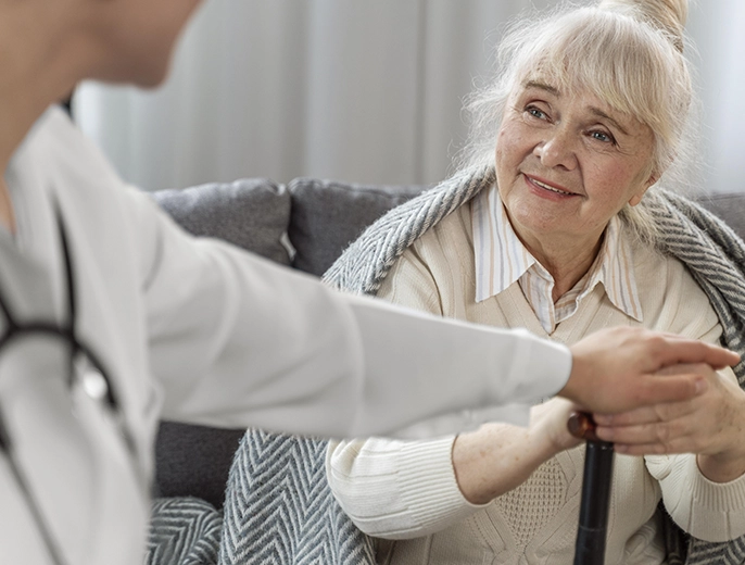 Palliative care doctor checking on elderly patient at home