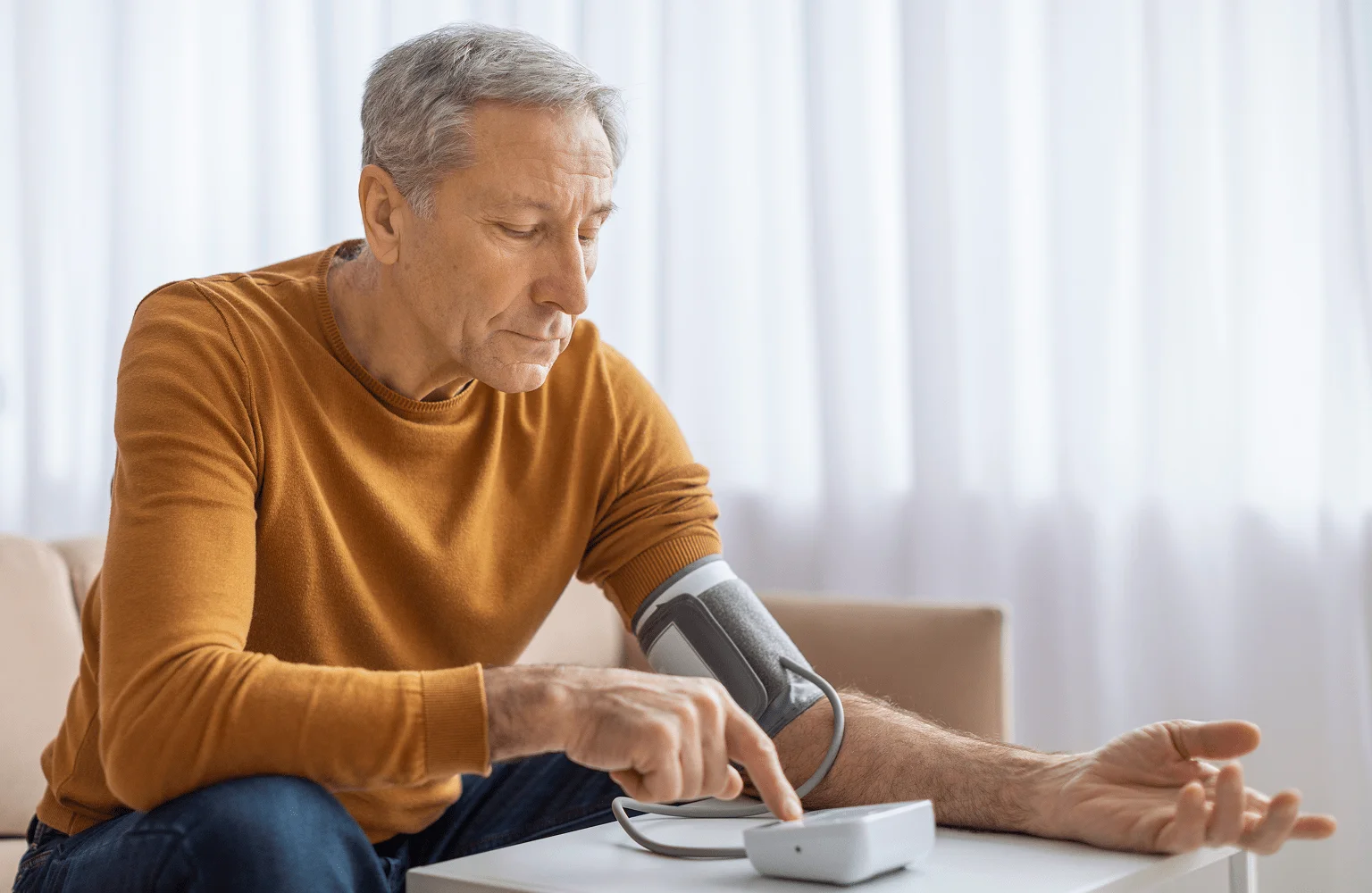 Man checking blood pressure with remote monitoring device